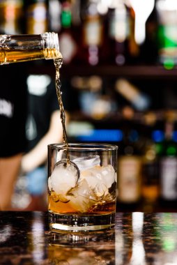 Viski bardağa dökülür. Lokantadaki tezgahta bir bardak viski.