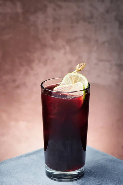 Červená bobule limonáda s ledem v krásném skle na texturovaném pozadí. Mezera pro text — Stock fotografie