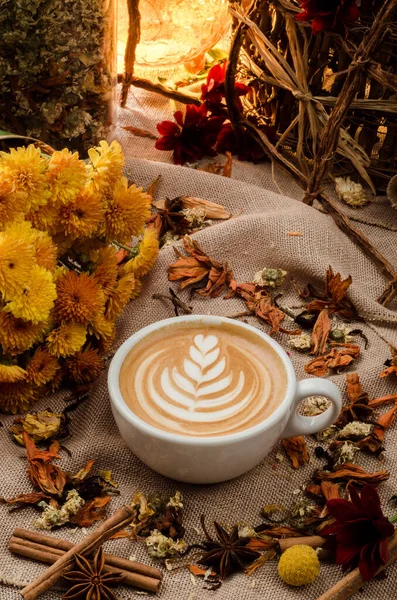 Café capuchino con hermoso patrón en espuma en taza blanca sobre fondo de arpillera decorado con especias. De cerca. Espacio para texto — Foto de Stock