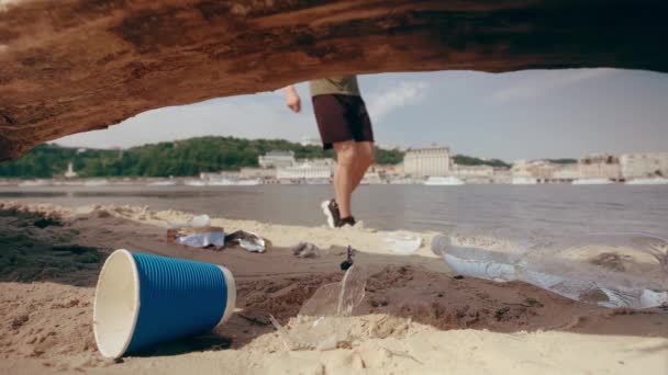 L'uomo raccoglie rifiuti di plastica sulla spiaggia. Inquinamento ambientale. Rallentamenti — Video Stock