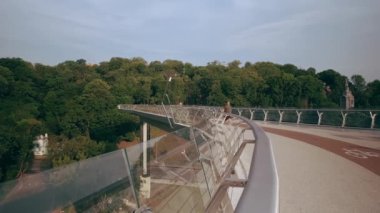 Spor üniformalı genç adam şafakta yaya köprüsünde koşar. Yavaş çekim