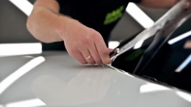 Otomatik temizleme. Beyaz araba için poliüretan film görüntülerini yapıştırma işlemi. Kapatın. Hareketi durdur