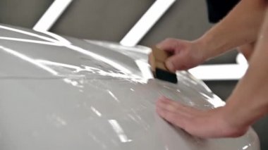 Otomatik temizleme. Beyaz araba için poliüretan film görüntülerini yapıştırma işlemi. Kapatın. Hareketi durdur