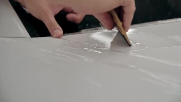 Auto detailing. Process of gluing footage of polyurethane film for white car. Close up. Stop motion — Stock Video