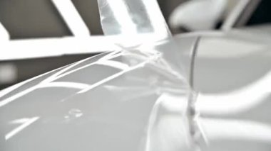 Otomatik temizleme. Beyaz araba için poliüretan film görüntülerini yapıştırma işlemi. Kapatın. Hareketi durdur