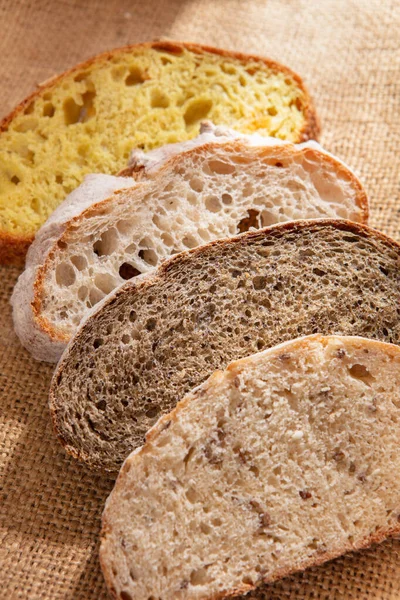 Különböző kenyerek szeletelt darabjai egy vászonközeli felvételen — Stock Fotó