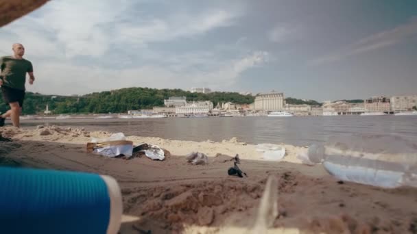 Мужчина собирает пластиковые отходы на пляже. Загрязнение окружающей среды Медленные движения — стоковое видео