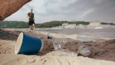 Adam plajda plastik atık topluyor. Çevre kirliliği. Yavaş hareketler
