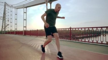 Genç koşucu antrenman sırasında dizini incitti. Şehirdeki yaya köprüsünde sabah koşusu