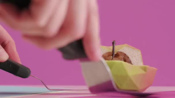 Pasticcere taglia dessert di marca sotto forma di mela su sfondo rosa colorato. Riempimento torta — Video Stock