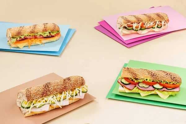Sandwich menu. Four different baguette sandwich with meat and vegetables on a colored background. Space for text