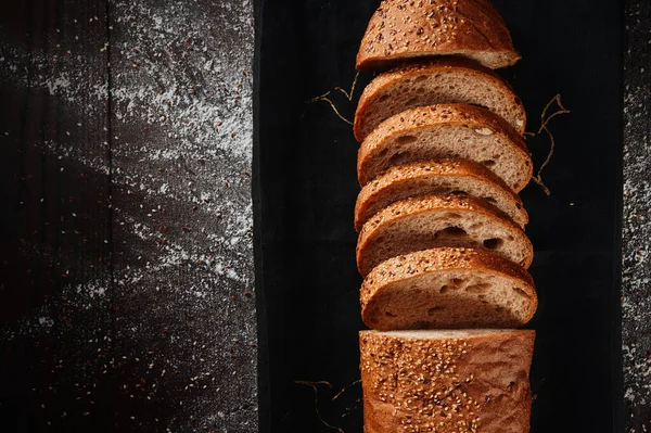 Asortyment pieczonego chleba z żyta i mąki pszennej na czarnym tle. Widok góry. Miejsce na tekst — Zdjęcie stockowe