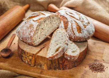 Çavdar ekmeği ve ahşap zemin üzerinde buğday unu çeşitleri.