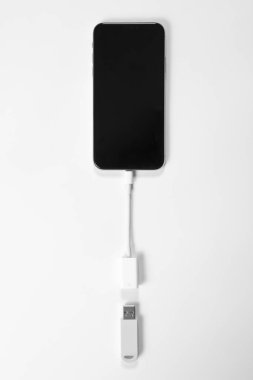 Taşınabilir USB bellek beyaz arka planda izole edilmiş cep telefonuna bağlı. Model.