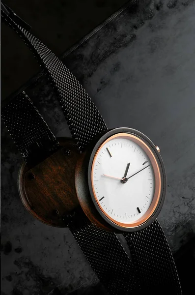 Elegante orologio da polso da donna in legno con quadrante bianco su sfondo scuro strutturato con riflesso. Spazio per testo — Foto Stock