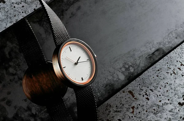 Elegante reloj de pulsera para mujer de madera con esfera blanca sobre fondo oscuro texturizado con reflejo. Espacio para texto — Foto de Stock
