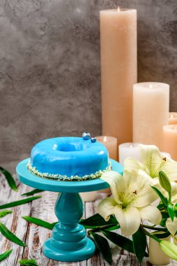 Beyaz ahşap bir arka planda pasta standında mavi kremalı pasta. Metin için boşluk