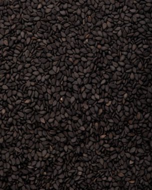 Beyaz bir zeminde izole edilmiş siyah susam tohumları..