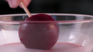 Pasta şefi dondurulmuş keki pembe kremaya batırıyor. Tatlı yapma süreci