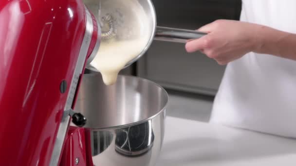 Pastelero vierte las proteínas en el procesador de alimentos rojos para hacer masa. Proceso de preparación de postres — Vídeos de Stock