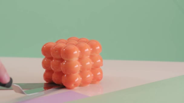 Banketbakker snijdt oranje mousse mini cake op gekleurde groene achtergrond. Taartvulling — Stockvideo