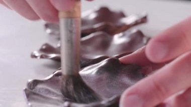 Pasta şefi pastayı süslemek için çikolatayı gri kandurinle kaplıyor. Tatlı yapma süreci