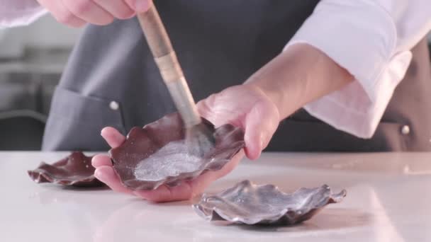 De banketbakker bedekt de chocolade met grijze kandurin om de taart te versieren. Dessert maakproces — Stockvideo