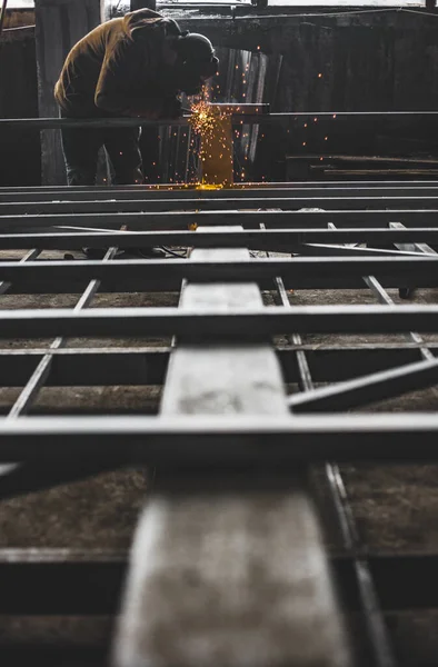 Worker welding the construction metal steel frames.