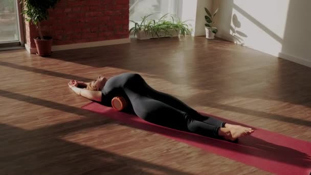 Entrenamiento de rodillo de espalda. Mujer haciendo estiramiento y masaje muscular con rodillo de espuma después del entrenamiento — Vídeos de Stock