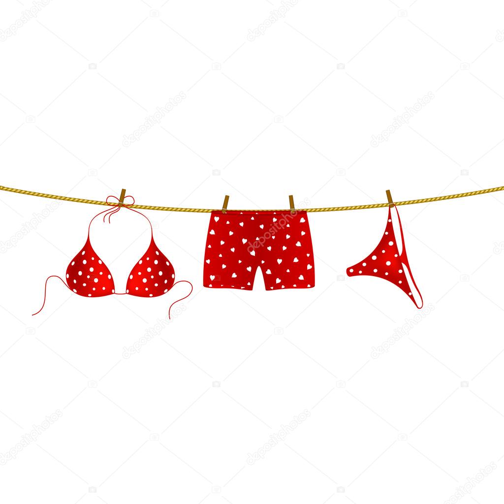 Red bikini suit with white dots and boxer shorts with white hearts hanging on rope