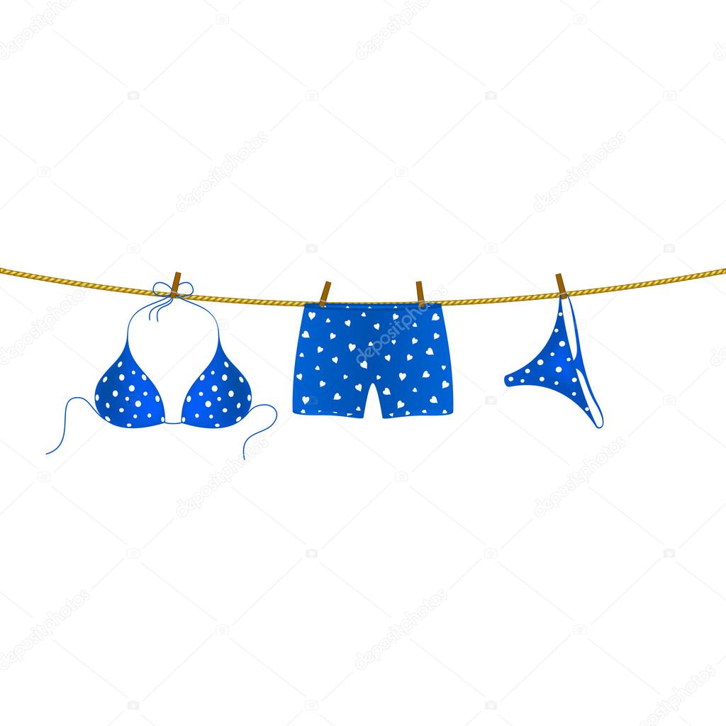 Blue bikini suit with white dots and boxer shorts with white hearts hanging on rope