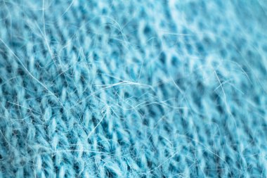 Örülmüş yün kumaş dokusu arka planı. Yumuşak odaklanma. Makro bulanık arkaplan. Mavi yün el örgüsü.