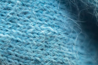 Örülmüş yün kumaş dokusu arka planı. Yumuşak odaklanma. Makro bulanık arkaplan. Mavi yün el örgüsü.