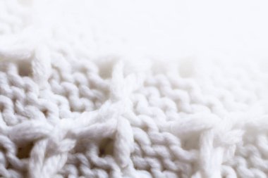 Örülmüş yün kumaş dokusu arka planı. Yumuşak odaklanma. Makro bulanık arkaplan. Beyaz yün el örgüsü.