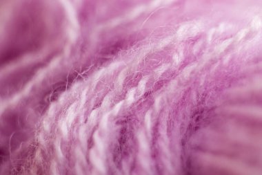 Örülmüş yün kumaş dokusu arka planı. Yumuşak odaklanma. Makro bulanık arkaplan. Pembe yün el örgüsü.