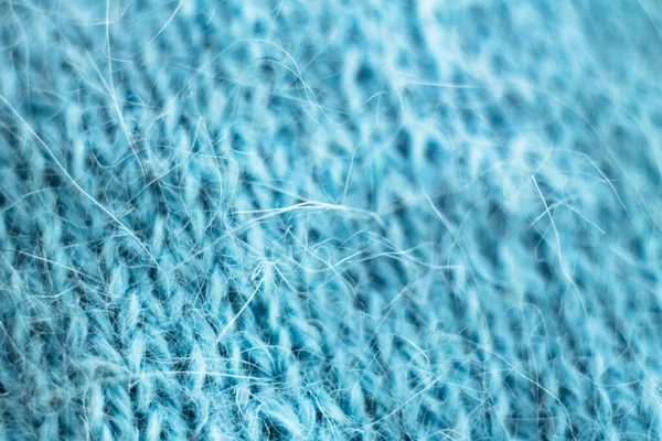 Örülmüş yün kumaş dokusu arka planı. Yumuşak odaklanma. Makro bulanık arkaplan. Mavi yün el örgüsü.