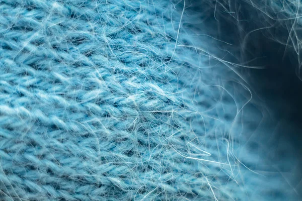 Örülmüş yün kumaş dokusu arka planı. Yumuşak odaklanma. Makro bulanık arkaplan. Mavi yün el örgüsü.