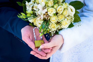 Yeni evliler ellerinde bir kale tutuyorlar. Gelin ve damat yakınlarda. Elinde buket olan gelin. Kış düğünü.