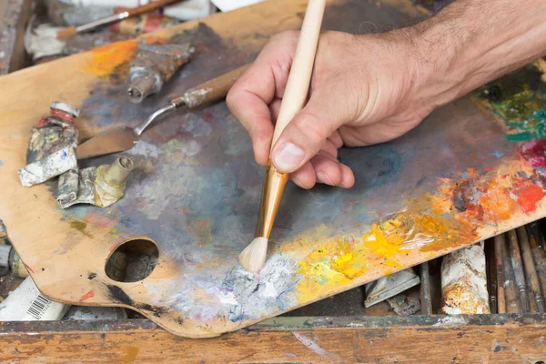 Mão masculina segurando pincel de pintura — Fotografia de Stock