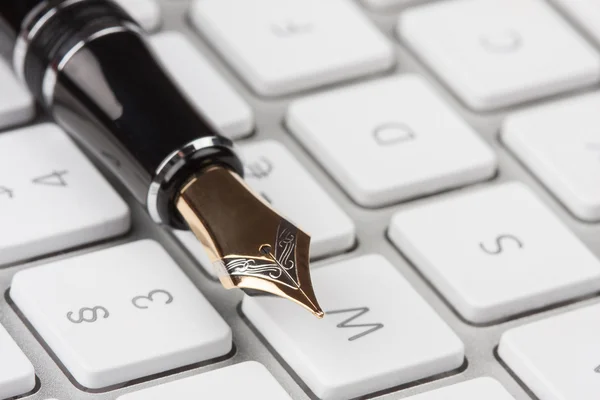 Viejo estilográfica acostado en un teclado de ordenador — Foto de Stock