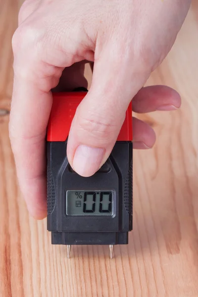 Female hand measuring moisture in wood — Stock Photo, Image