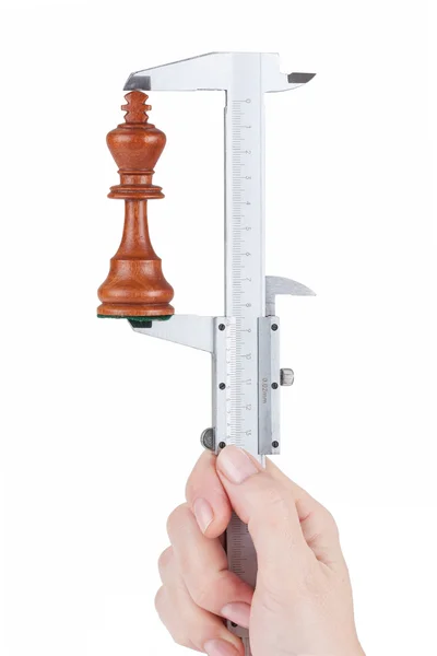 Female hand measures height chess king — Stock Photo, Image