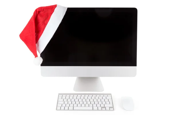 在现代的计算机显示器上的红色圣诞老人的帽子 — 图库照片