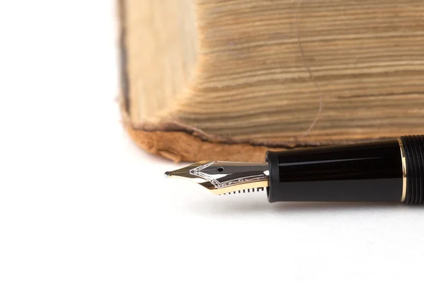 Фонтанная ручка и старая книга — стоковое фото