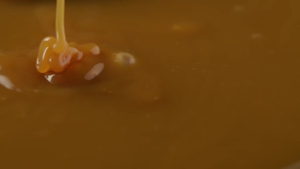Caramel with nuts. Pouring caramel syrup. 4k — Stock Video