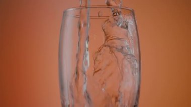 Suyu turuncu arka planda, cama yakın çekime dök