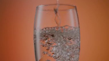 Suyu turuncu arka planda, cama yakın çekime dök