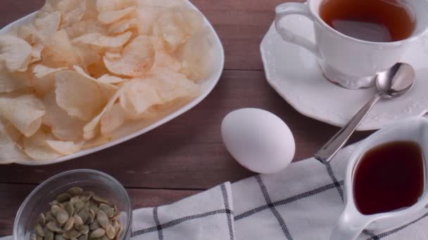 Taza de té negro y comida sobre fondo de mesa — Vídeo de stock