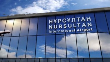 Nur-Sultan, Astana, Kazakistan 'a iniş yapan jet uçakları animasyon yapıyor. Cam havaalanı terminali ve uçağın yansıması ile şehre varış. Seyahat, turizm ve ulaşım kavramı.