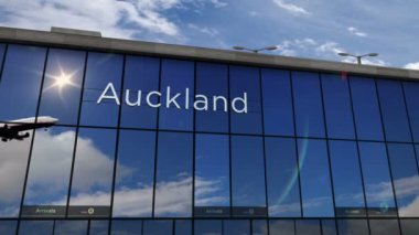 Auckland, Yeni Zelanda 'ya iniş yapan bir jet uçağı. Cam havaalanı terminali ve uçağın yansıması ile şehre varış. Seyahat, iş, turizm, ulaşım kavramı.